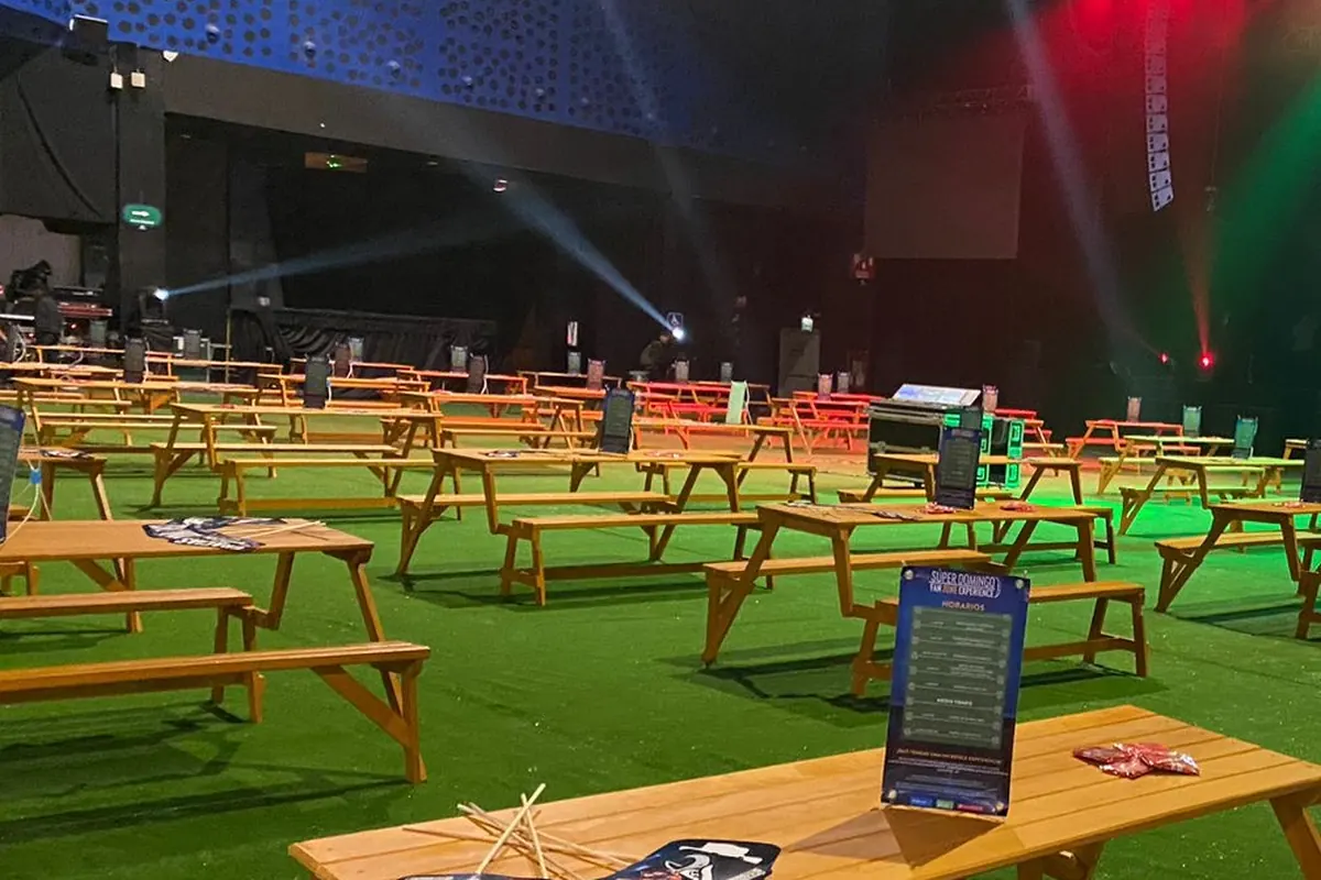 Fan zone con pantalla gigante, mobiliario e iluminación escénica